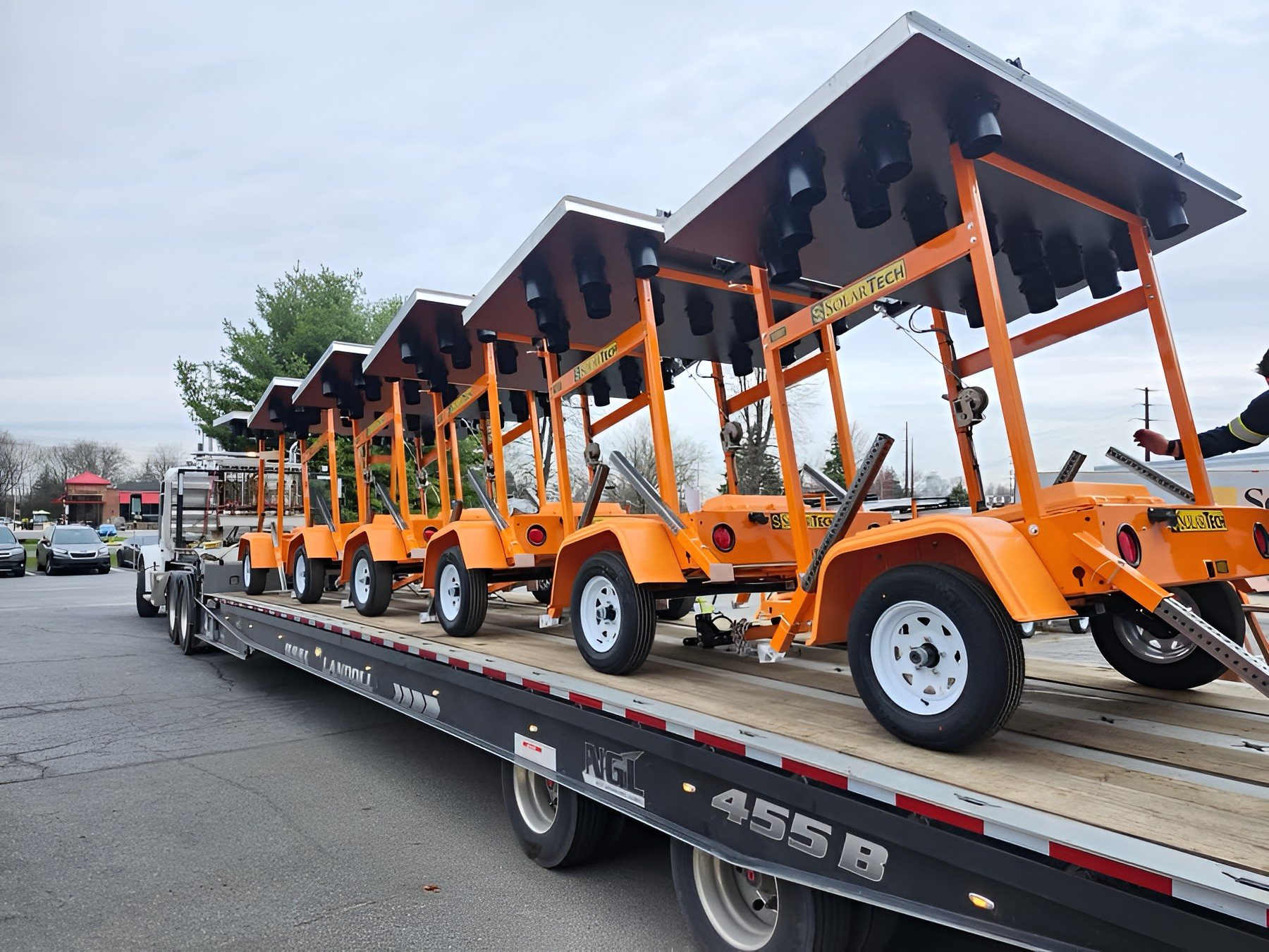 A truckload of orange SolarTech arrow boards on trailers, ready to ship
