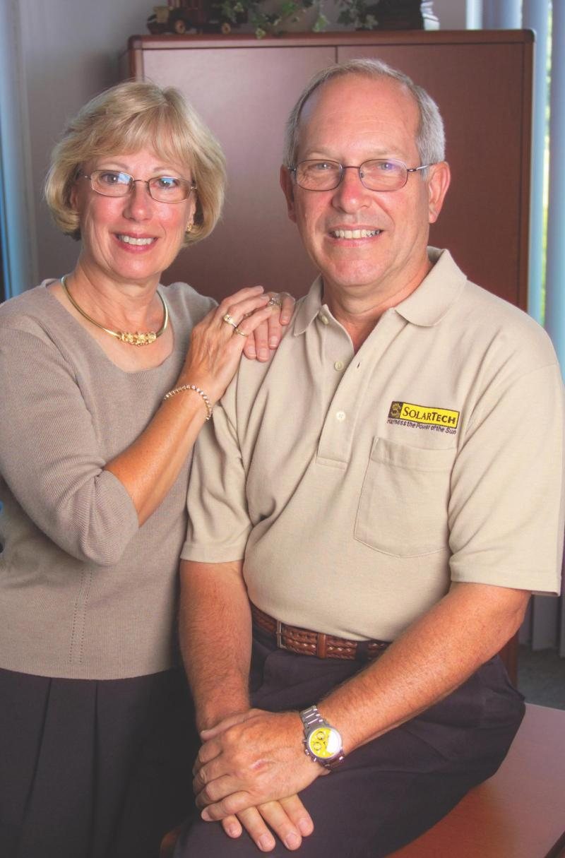 A smiling couple in a portrait, the man wearing a SolarTech polo shirt